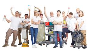 12 addetti alle pulizie posano felici tutti in maglia bianca con i loro attrezzi di lavoro esattamente sono 7 uomini e 5 donne con aspirapolvere cestini e prodotti delle pulizie